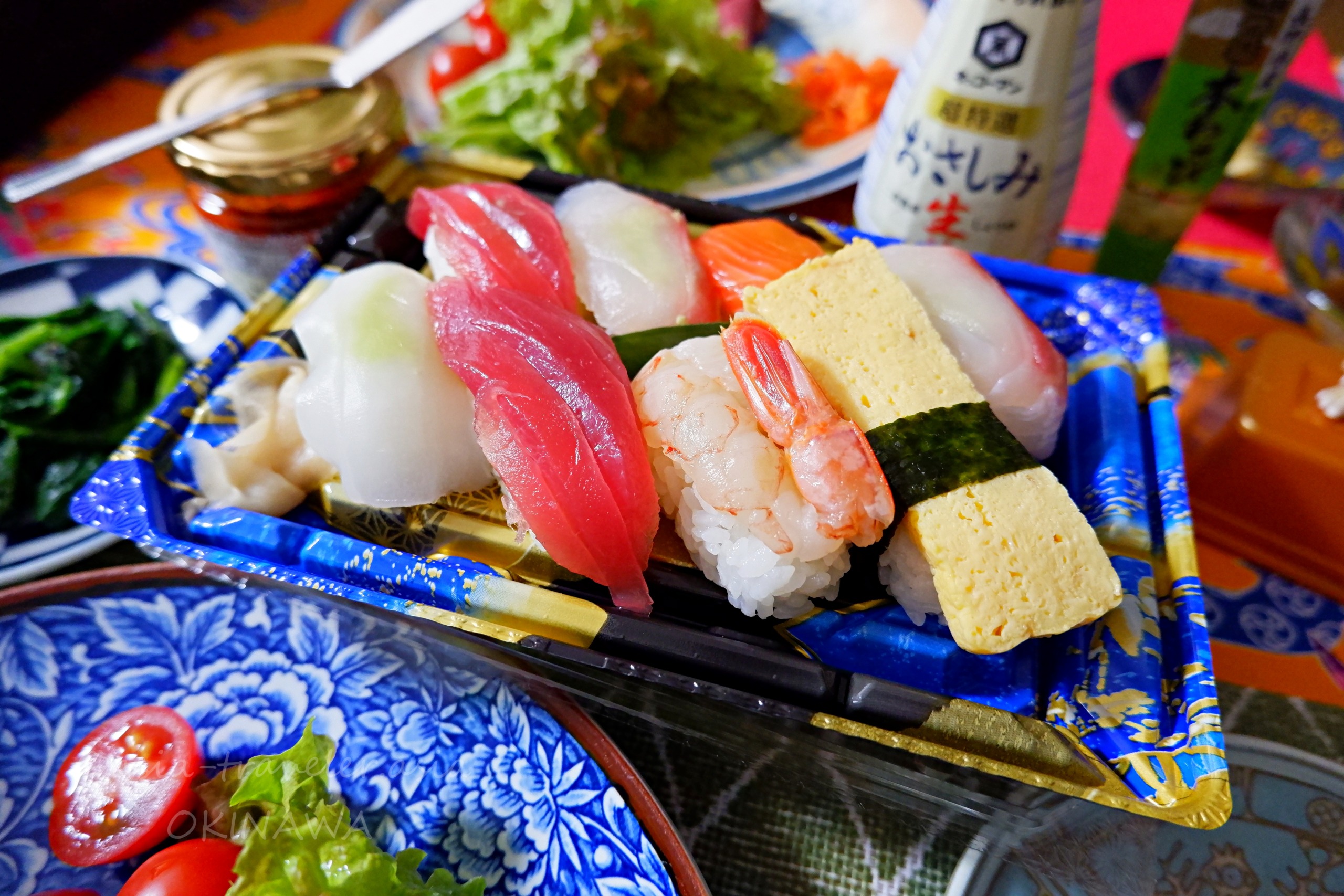 青い有田焼風皿に並ぶ沖縄で購入した握り寿司の盛り合わせ