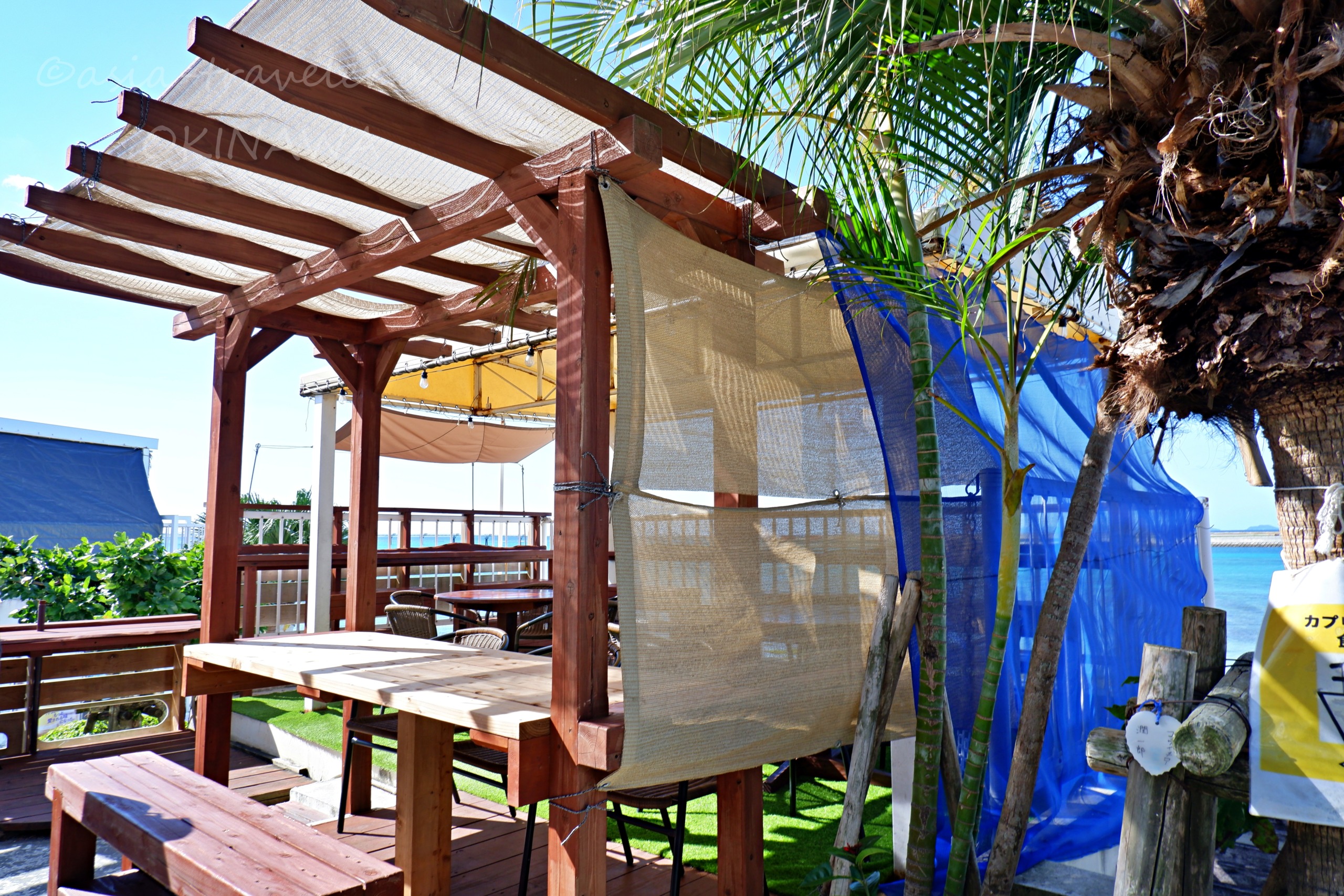 ウミカジテラスのウッドデッキテラス席と青い遮光ネット