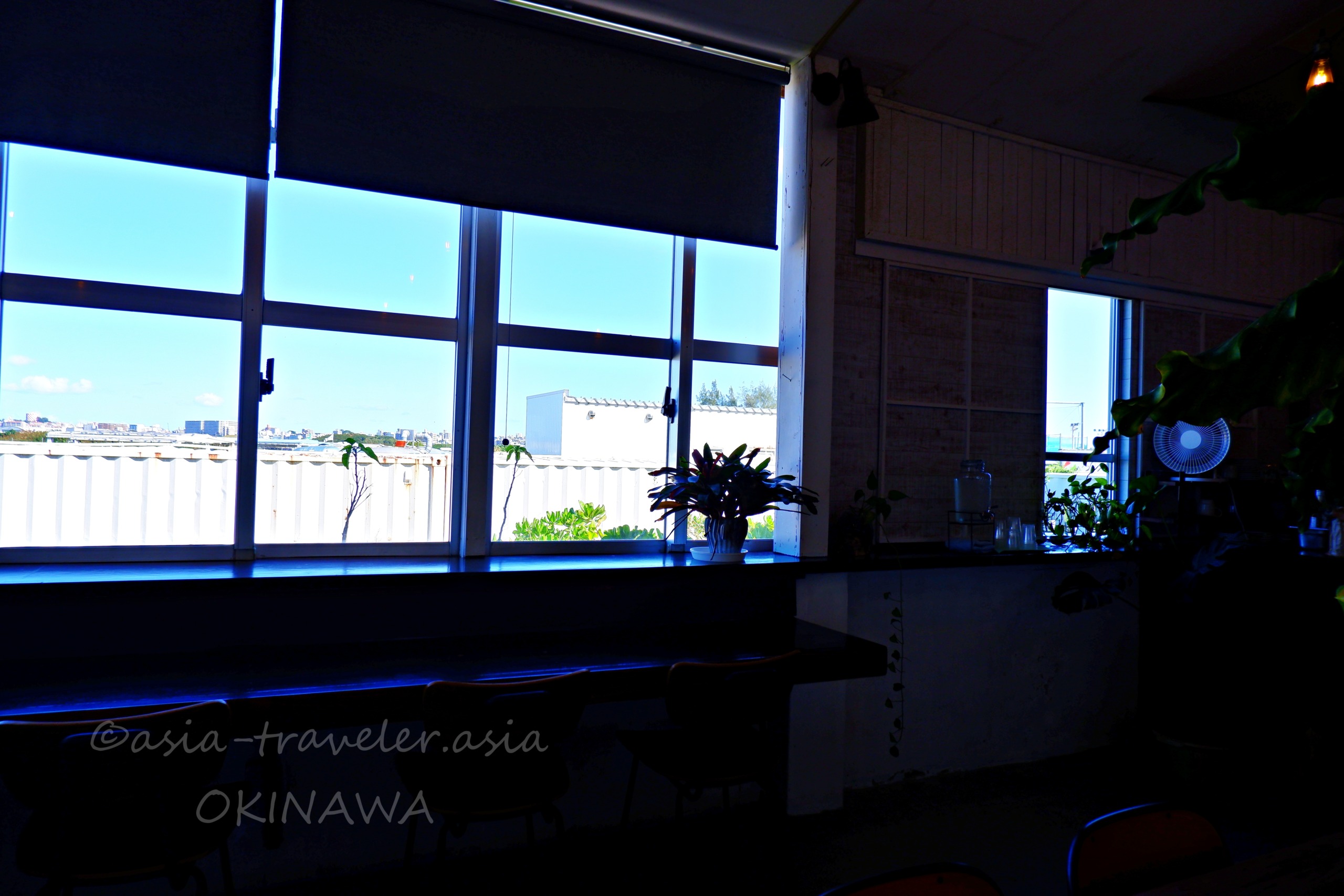 瀬長珈琲の大きな窓越しに青空が広がる店内カウンター席