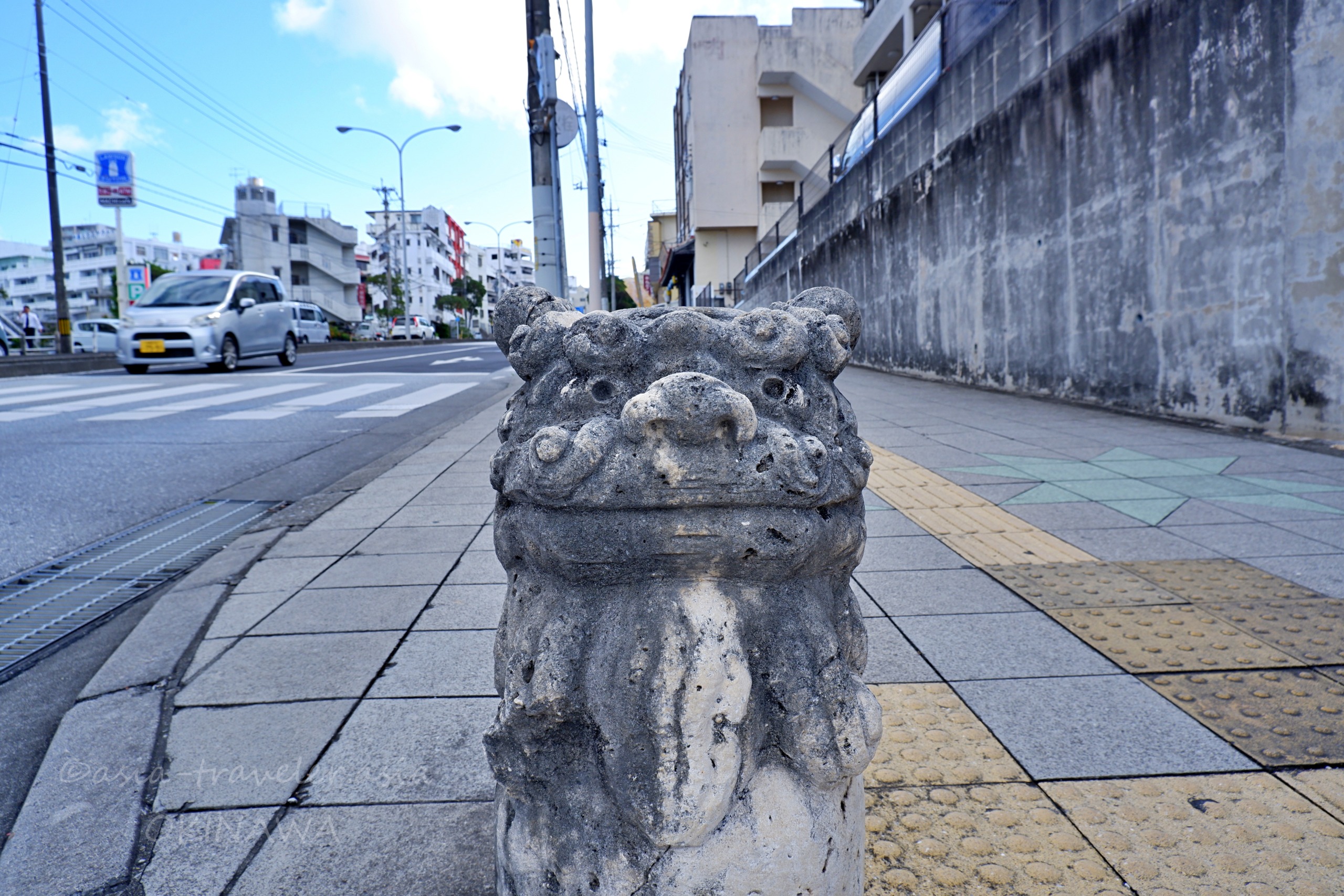 那覇・与儀公園近くの遊歩道に立つ石造りのシーサー