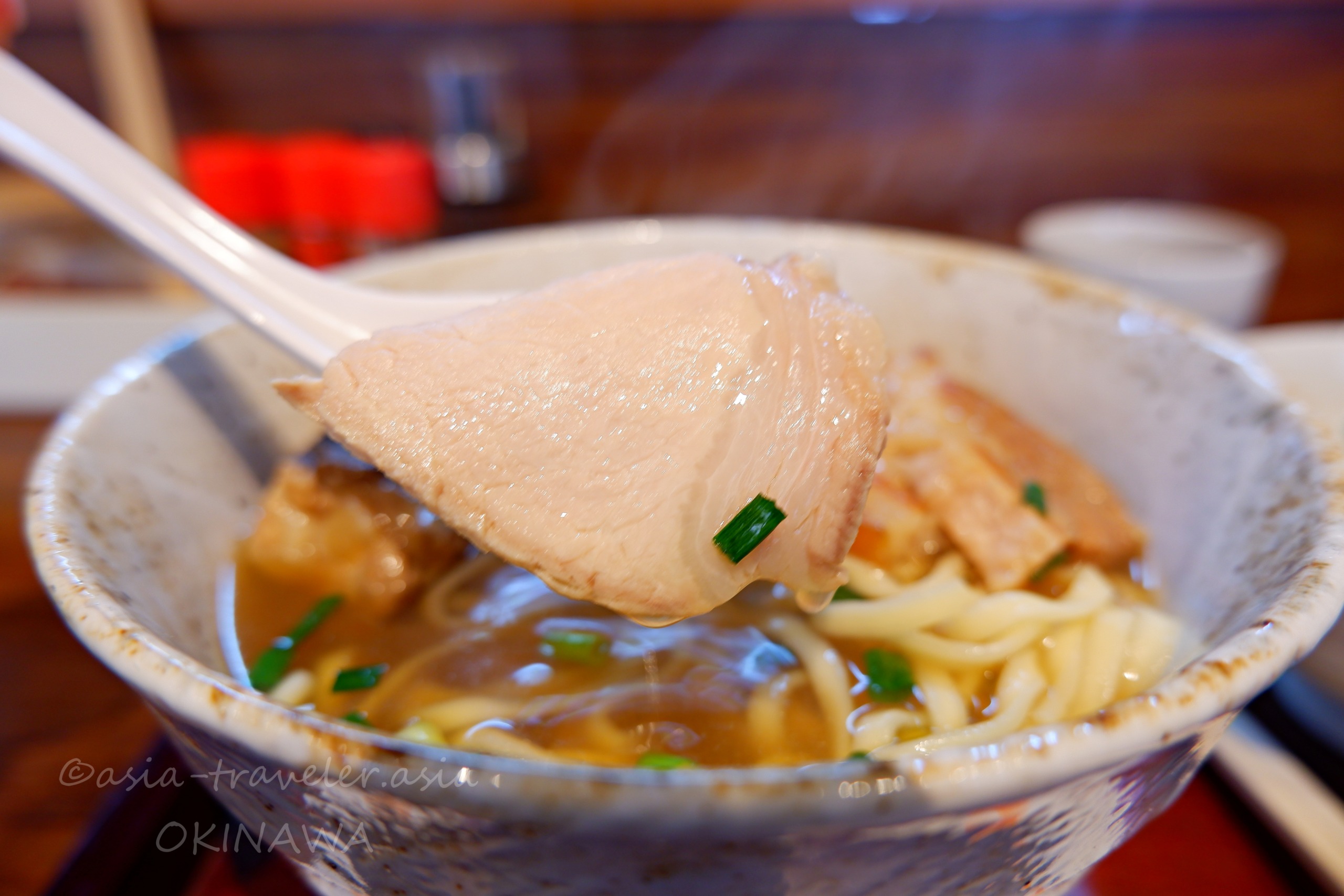 麺屋あんの沖縄そば・三枚肉をレンゲで持ち上げたアップ