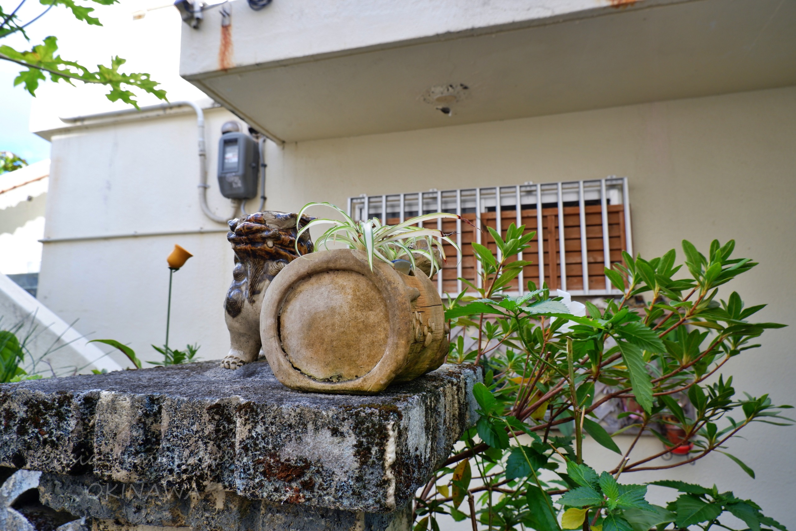那覇・長田の路地に佇む風化したシーサーの置物