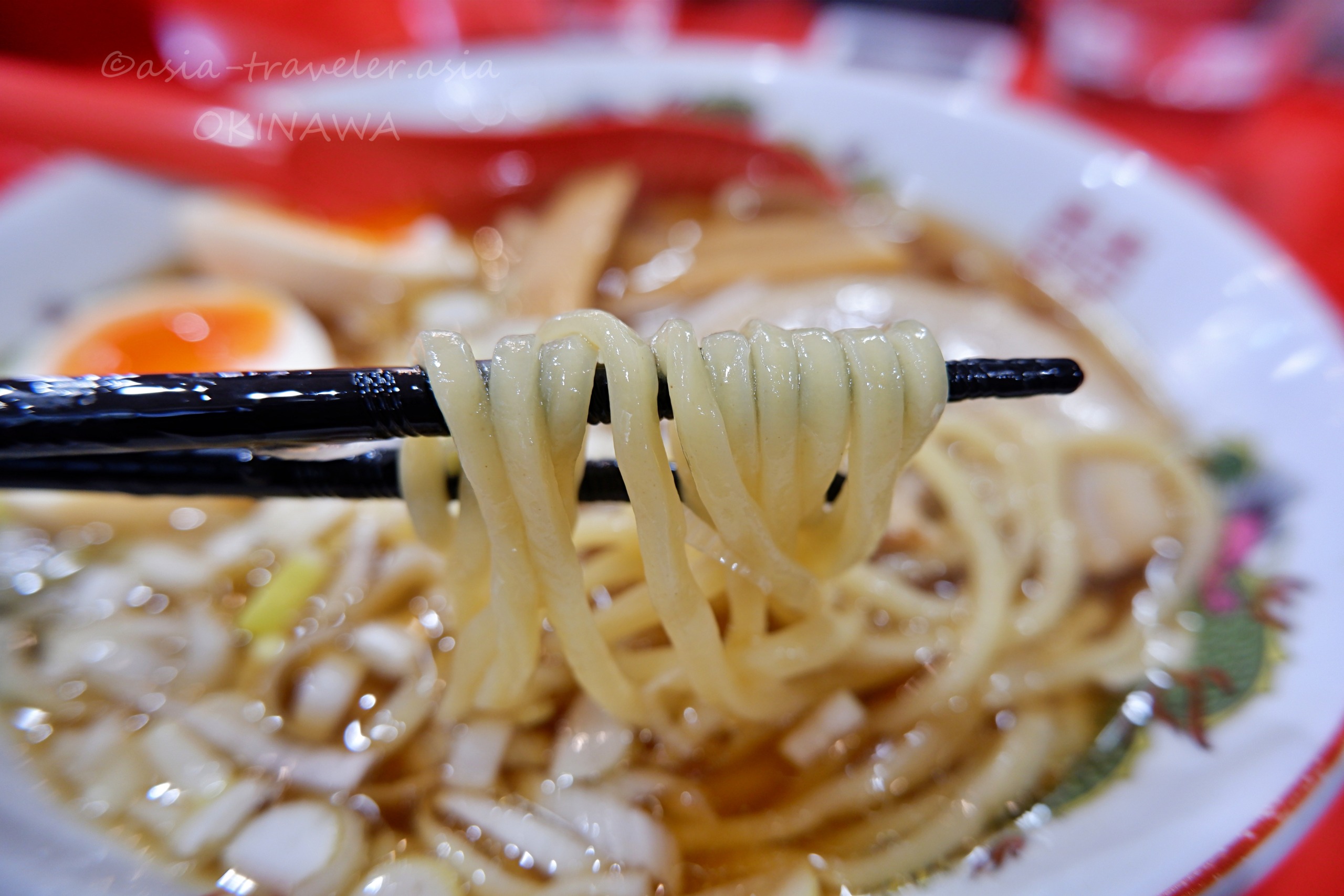 沖縄Agu豚の中華麺を箸で持ち上げたアップ