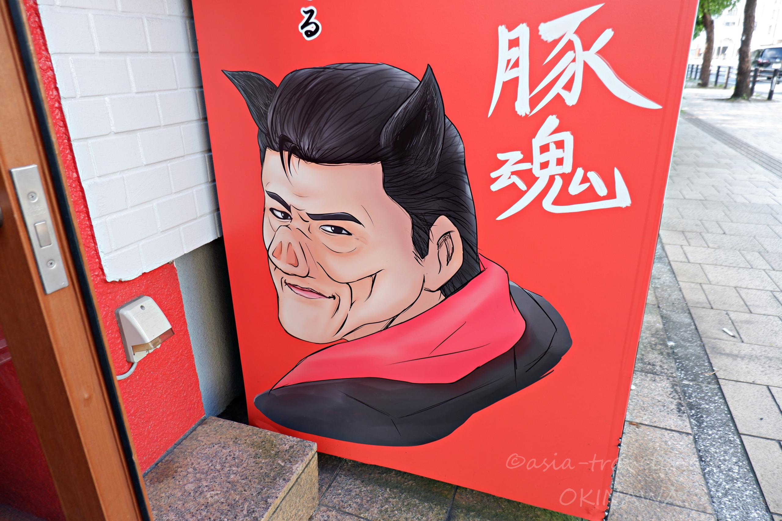 豚魂の赤い看板に描かれたインパクト大のキャラクターイラスト