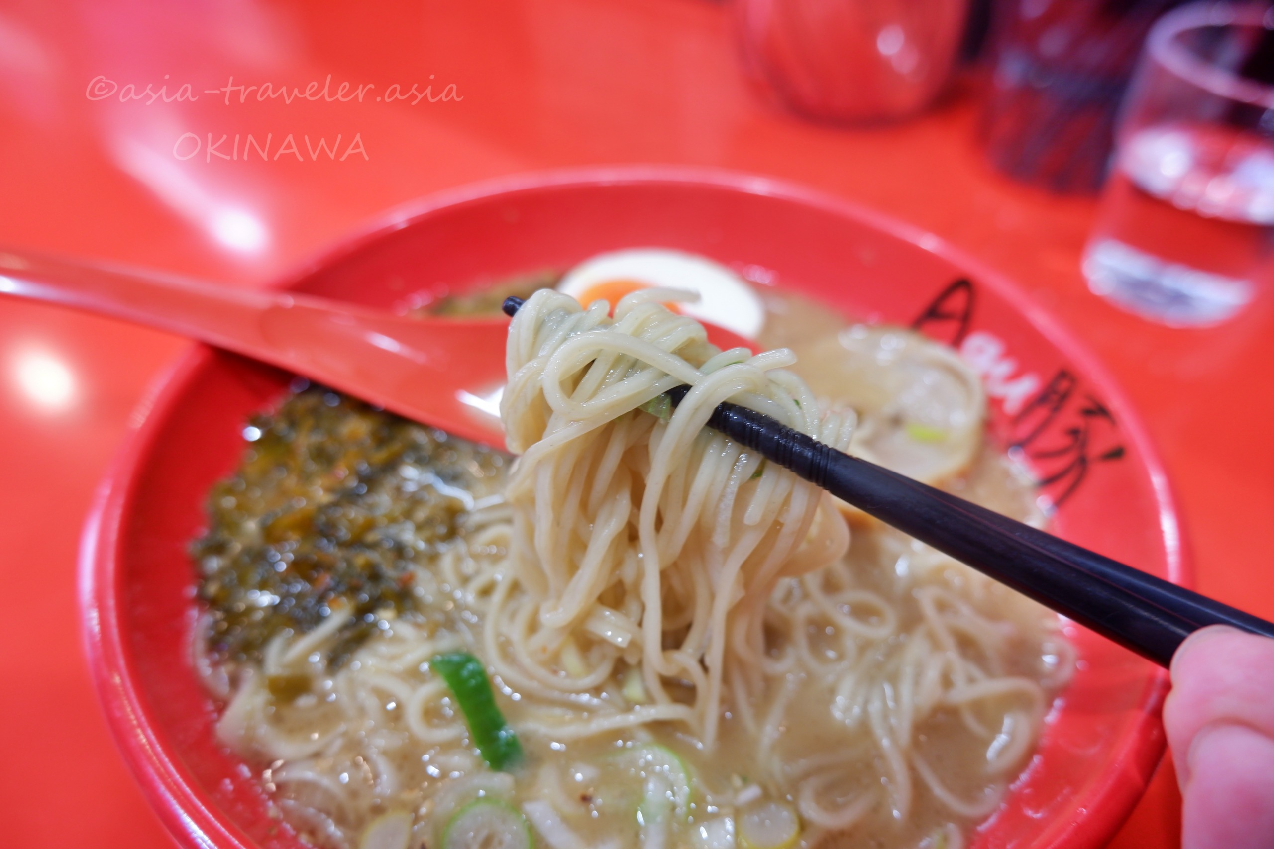 Agu豚の白豚骨らーめん麺を箸で持ち上げた様子