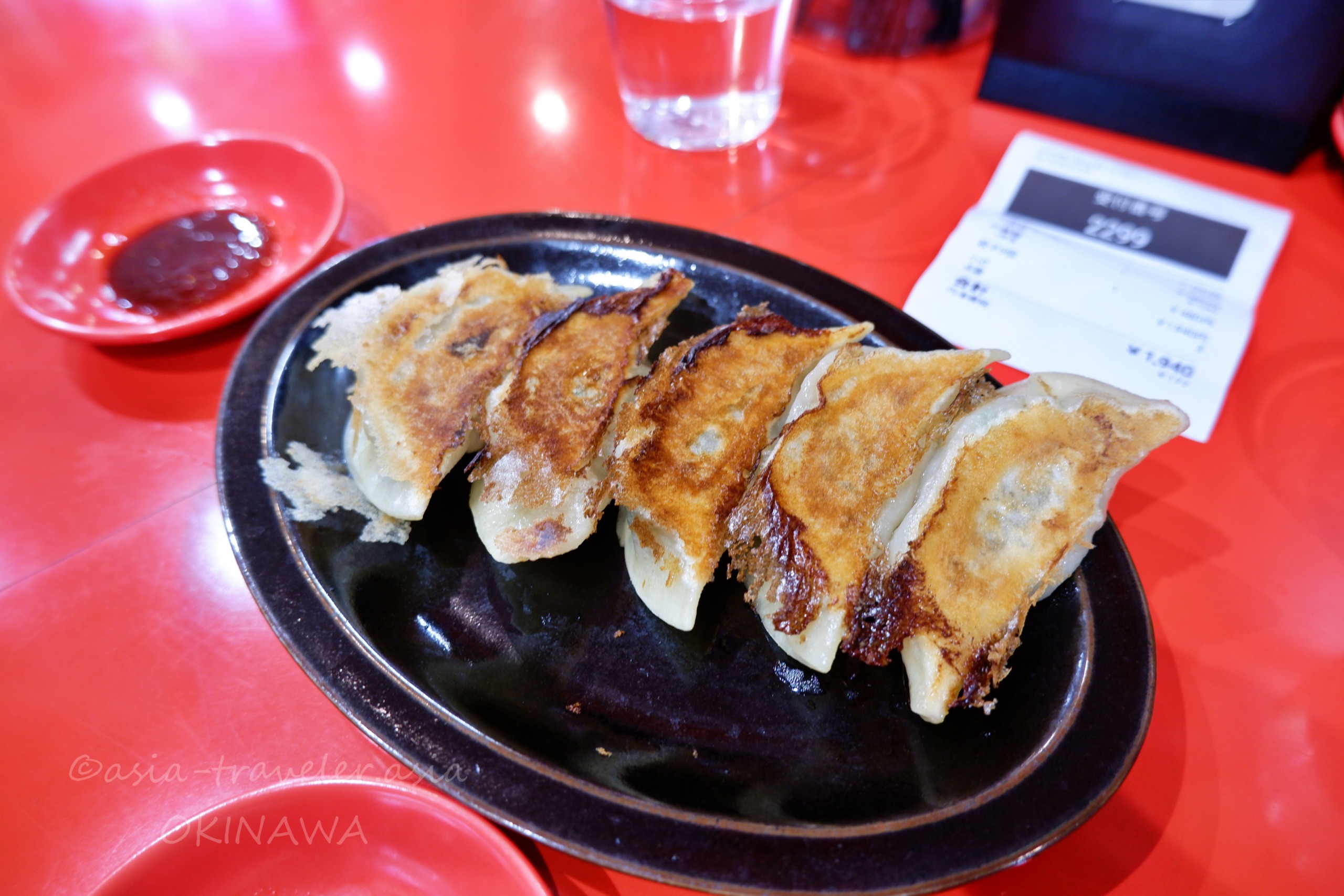 Agu豚久茂地店の手作り餃子5個が鉄皿に並ぶ