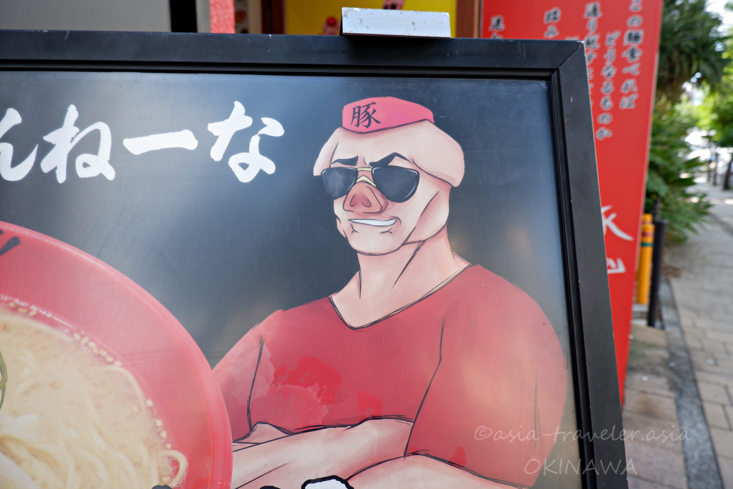 Agu豚久茂地店の豚キャラクターが描かれた個性的な店頭看板