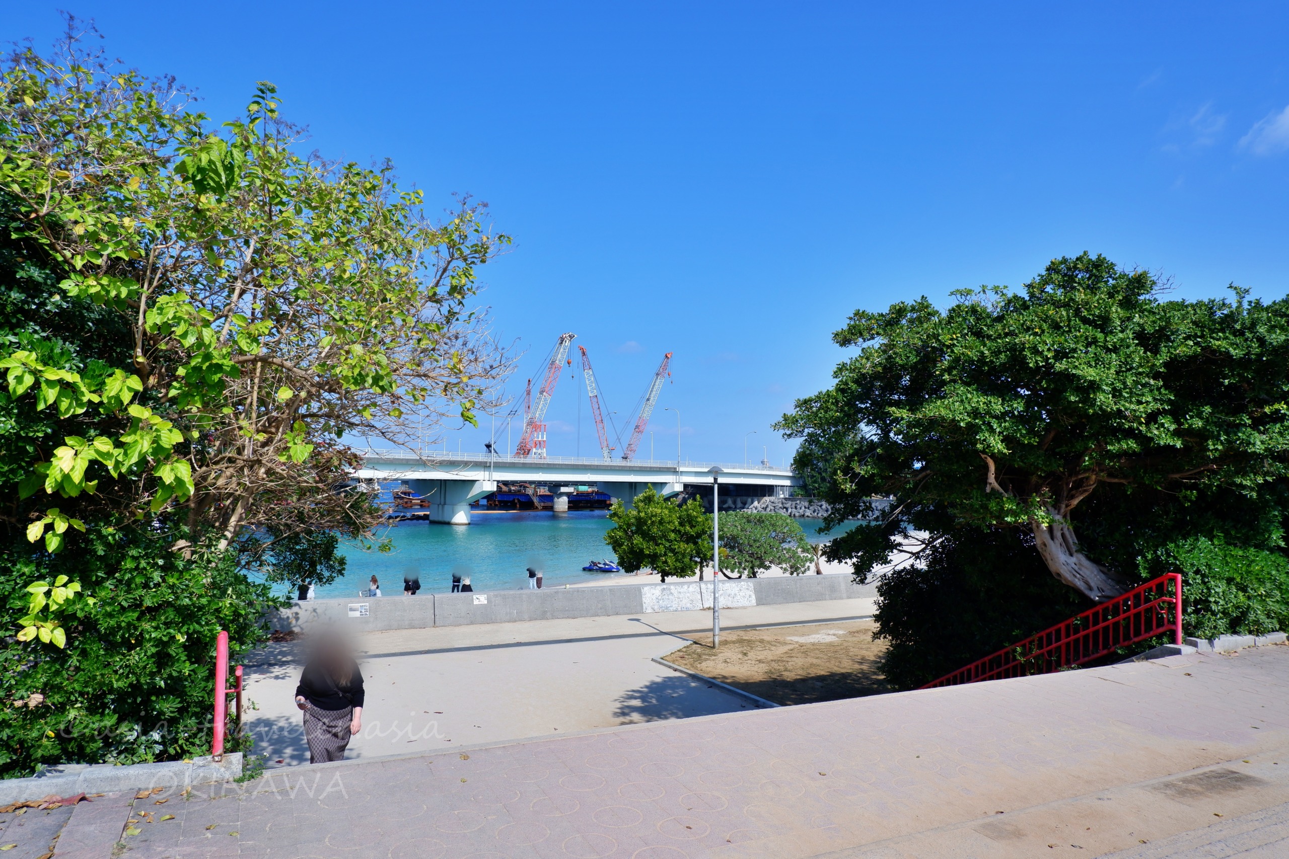 波の上ビーチと工事中の橋が見える那覇の海辺の風景