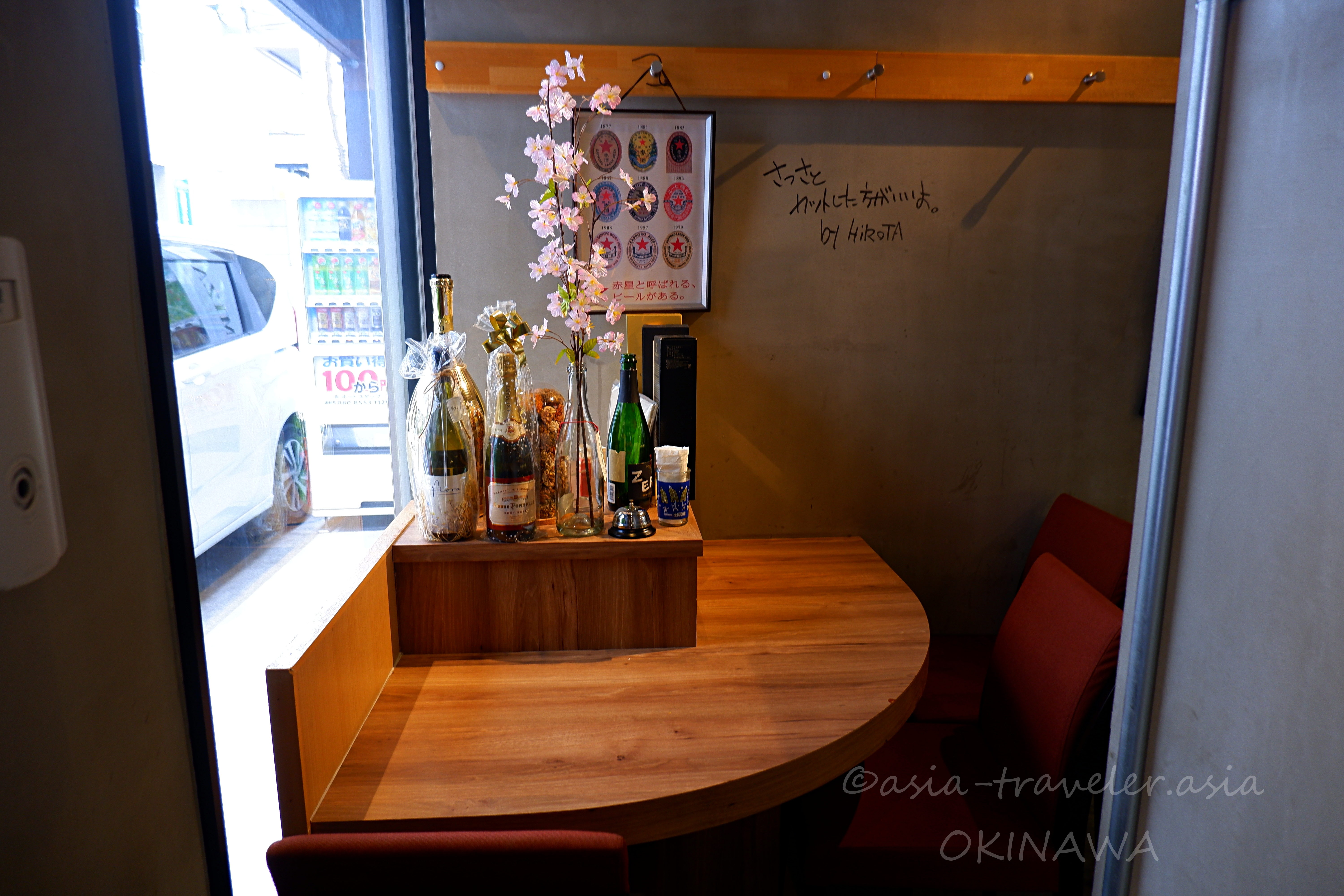 那覇・益々の窓際ボックス席とワインボトルが並ぶ店内