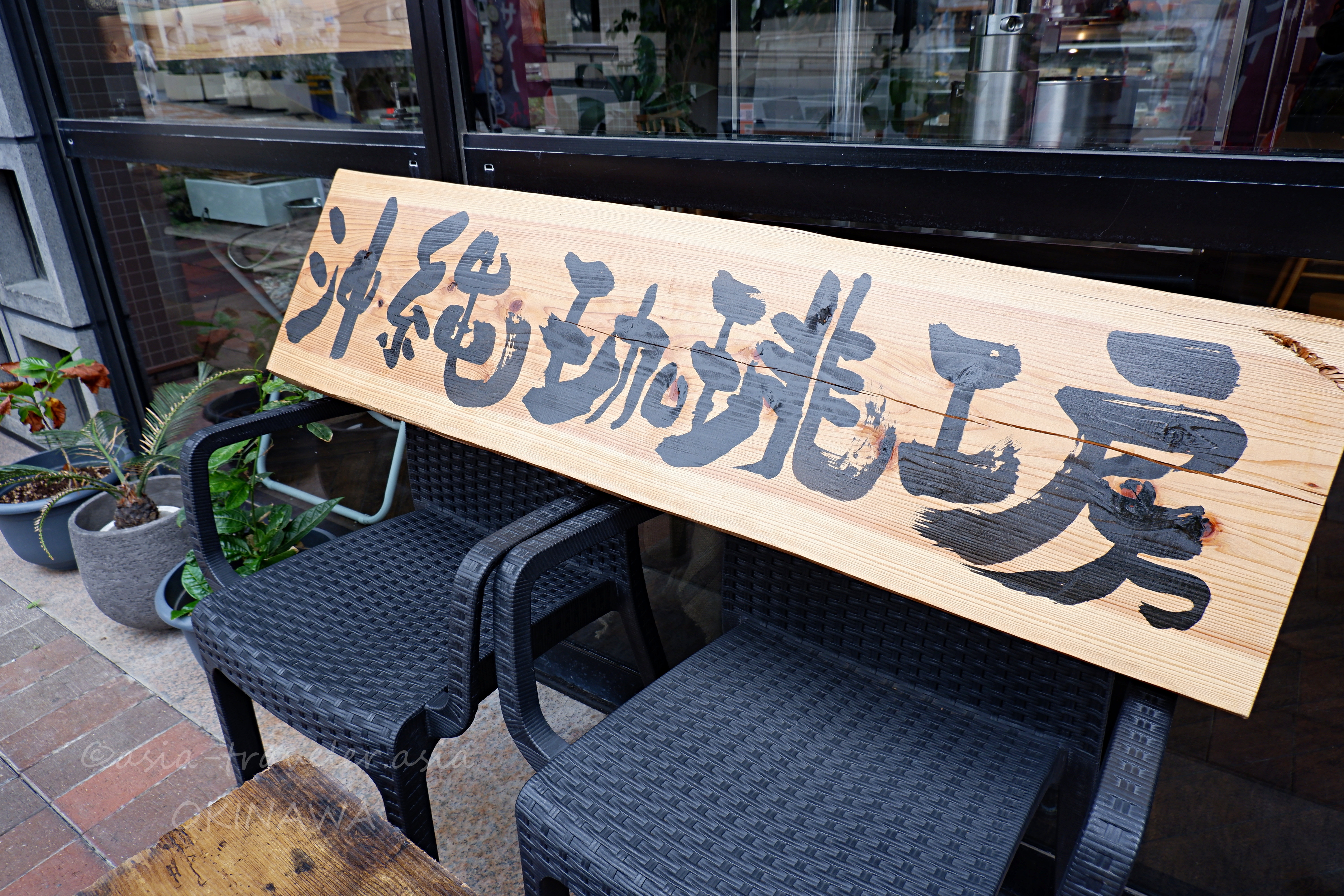 沖縄珈琲工房の木製看板がカフェ店頭に掲げられた外観