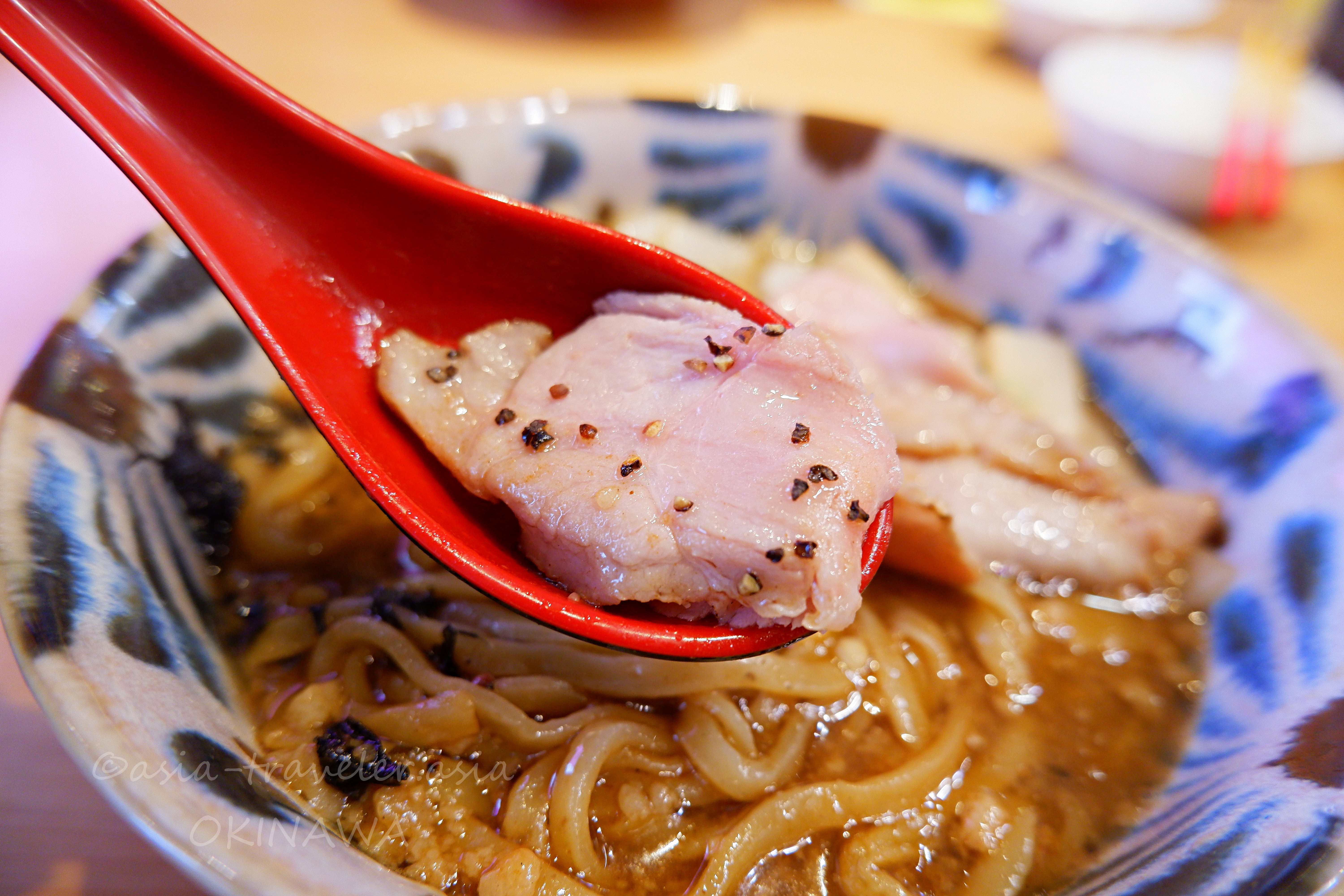 益々のレアチャーシューを赤いレンゲで持ち上げるアップ