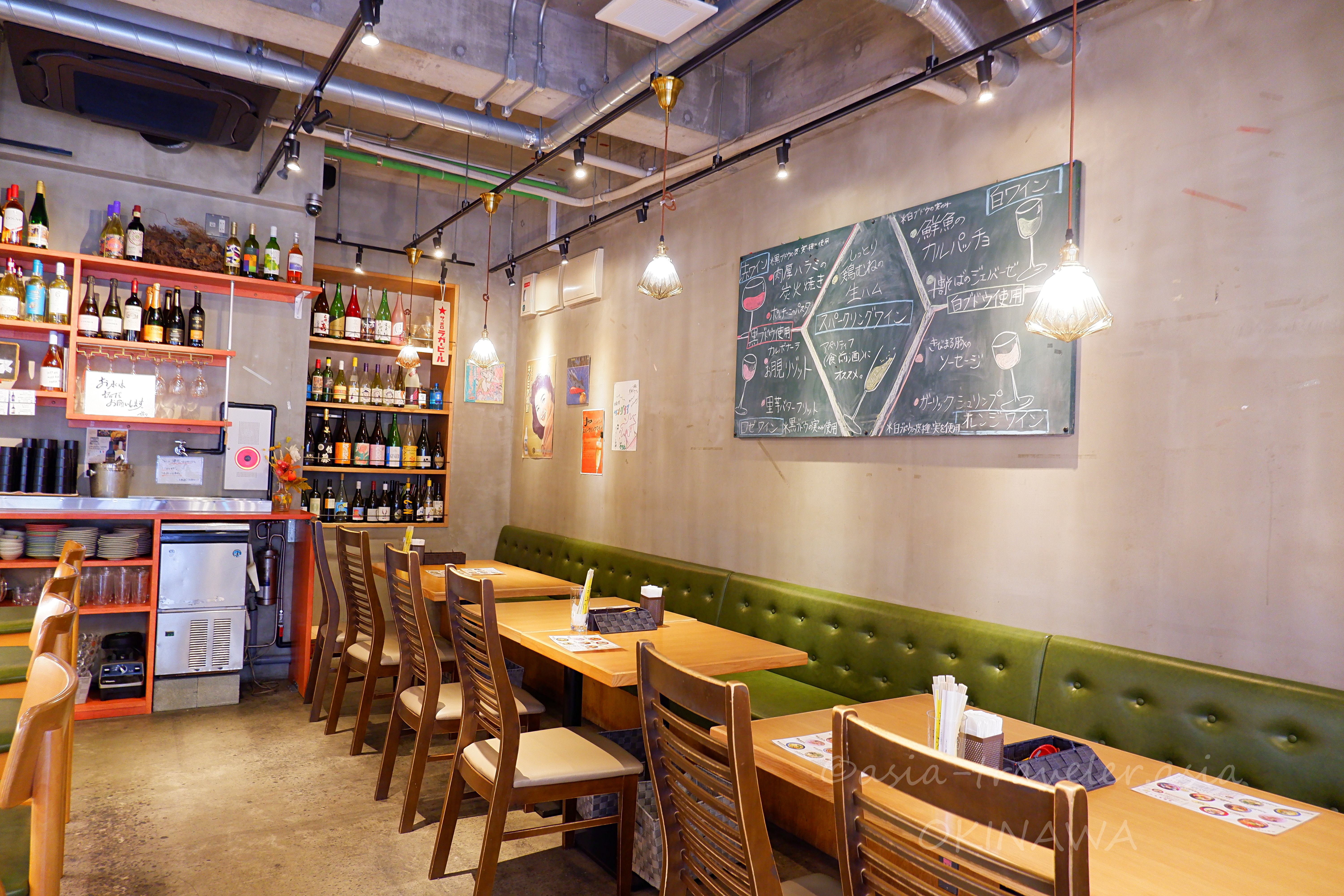 益々のワインが並ぶ棚と黒板メニューが彩る落ち着いた店内