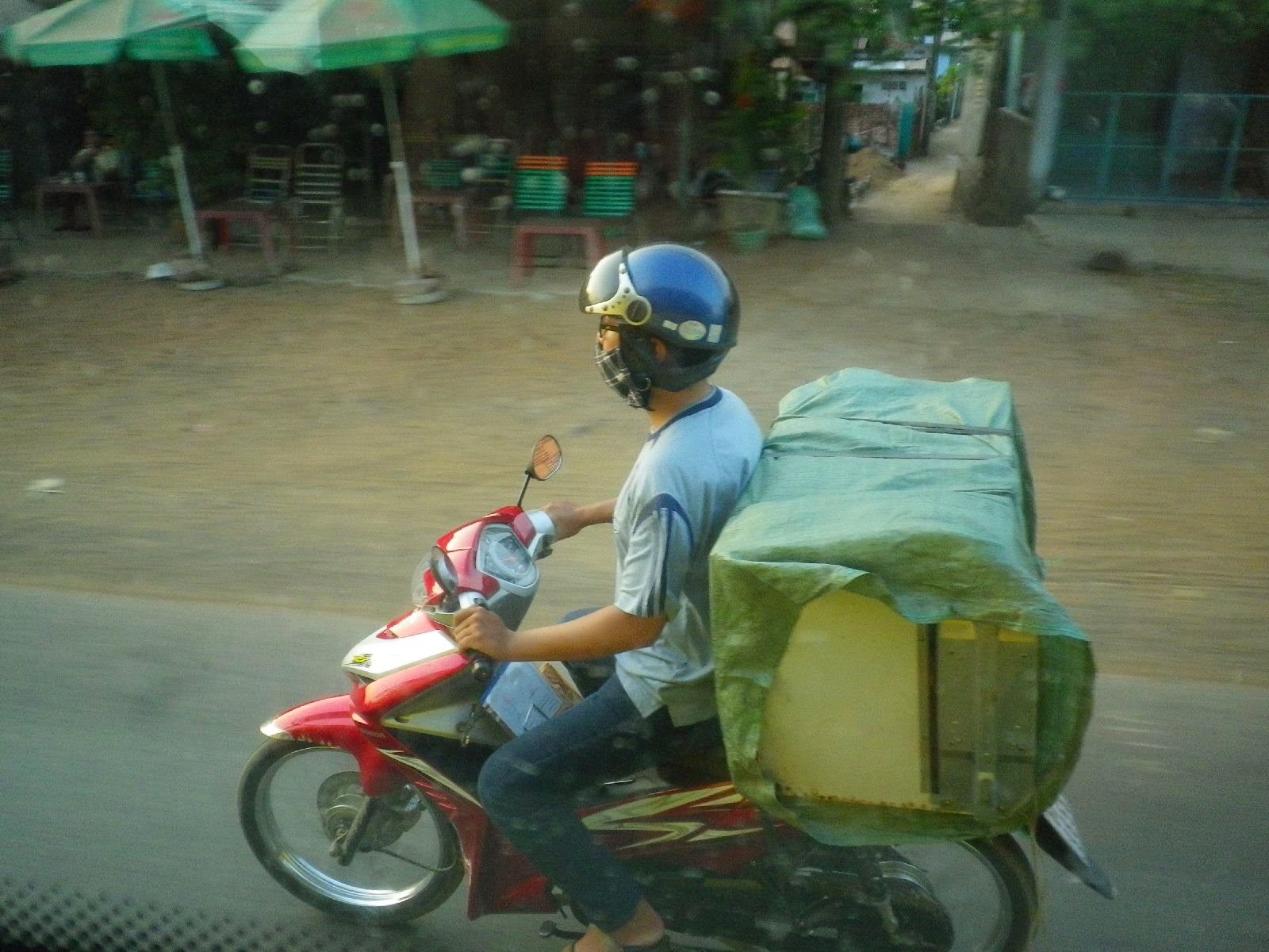 ベトナムの街中で大荷物を積んで走るバイク