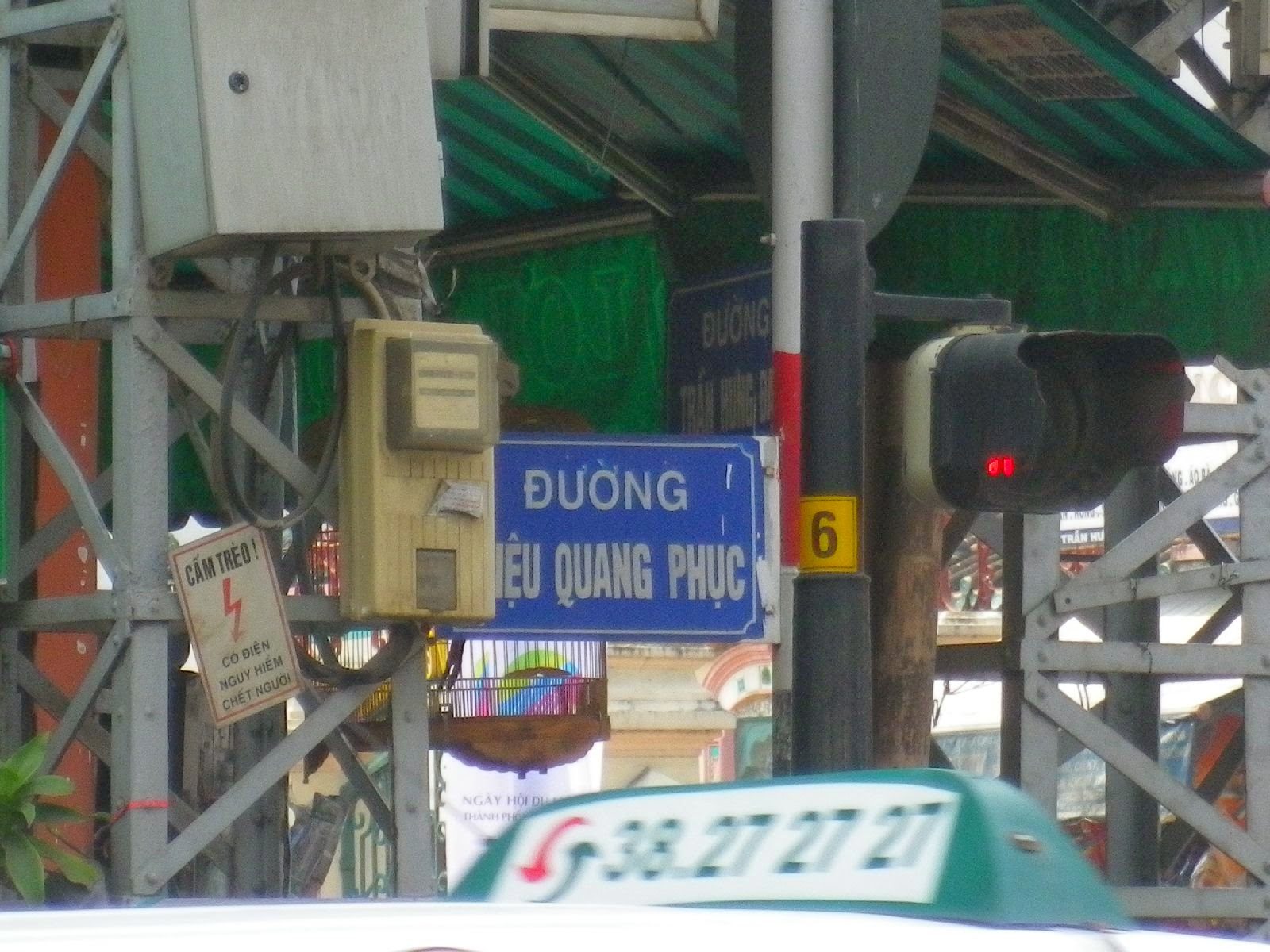 ホーチミン・チョロン地区のĐường Triệu Quang Phục交差点標識と信号機