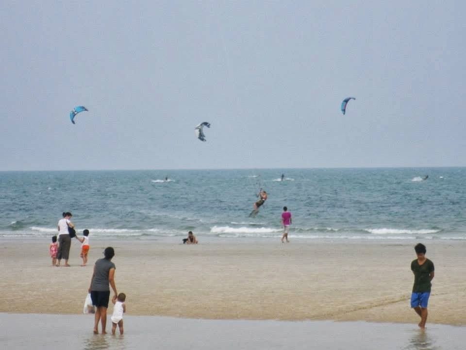 ホアヒンビーチでカイトサーフィンを楽しむ人々と砂浜の観光客