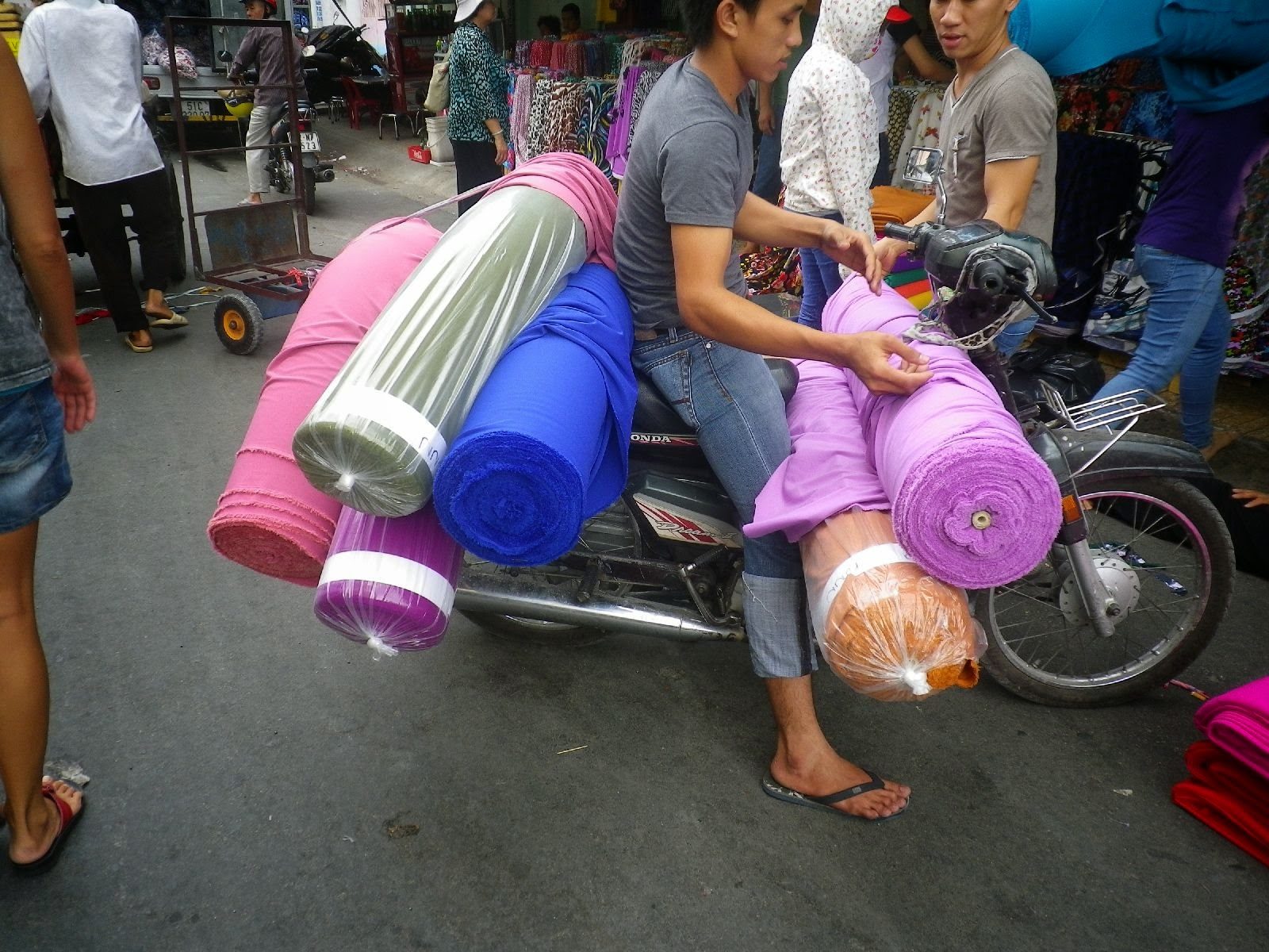 カラフルな布ロールを積み過ぎたバイク・チョロンの街角