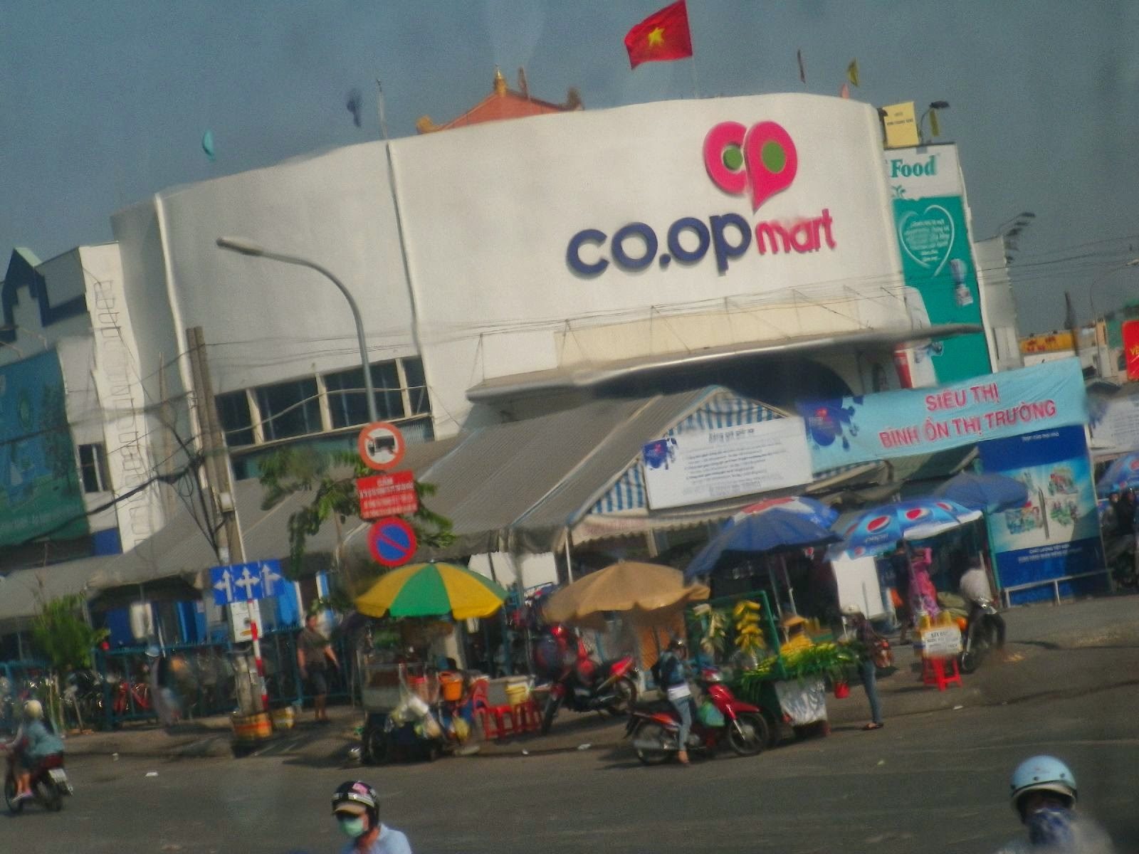 ベトナム・ホーチミンのCo.opMartとバイク屋台が並ぶ街角