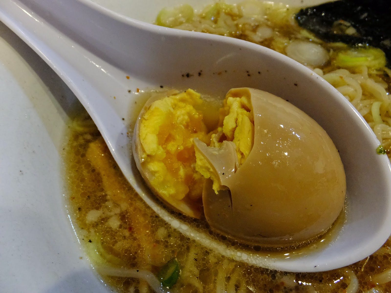 とみだやラーメンの味玉をレンゲにのせた断面アップ
