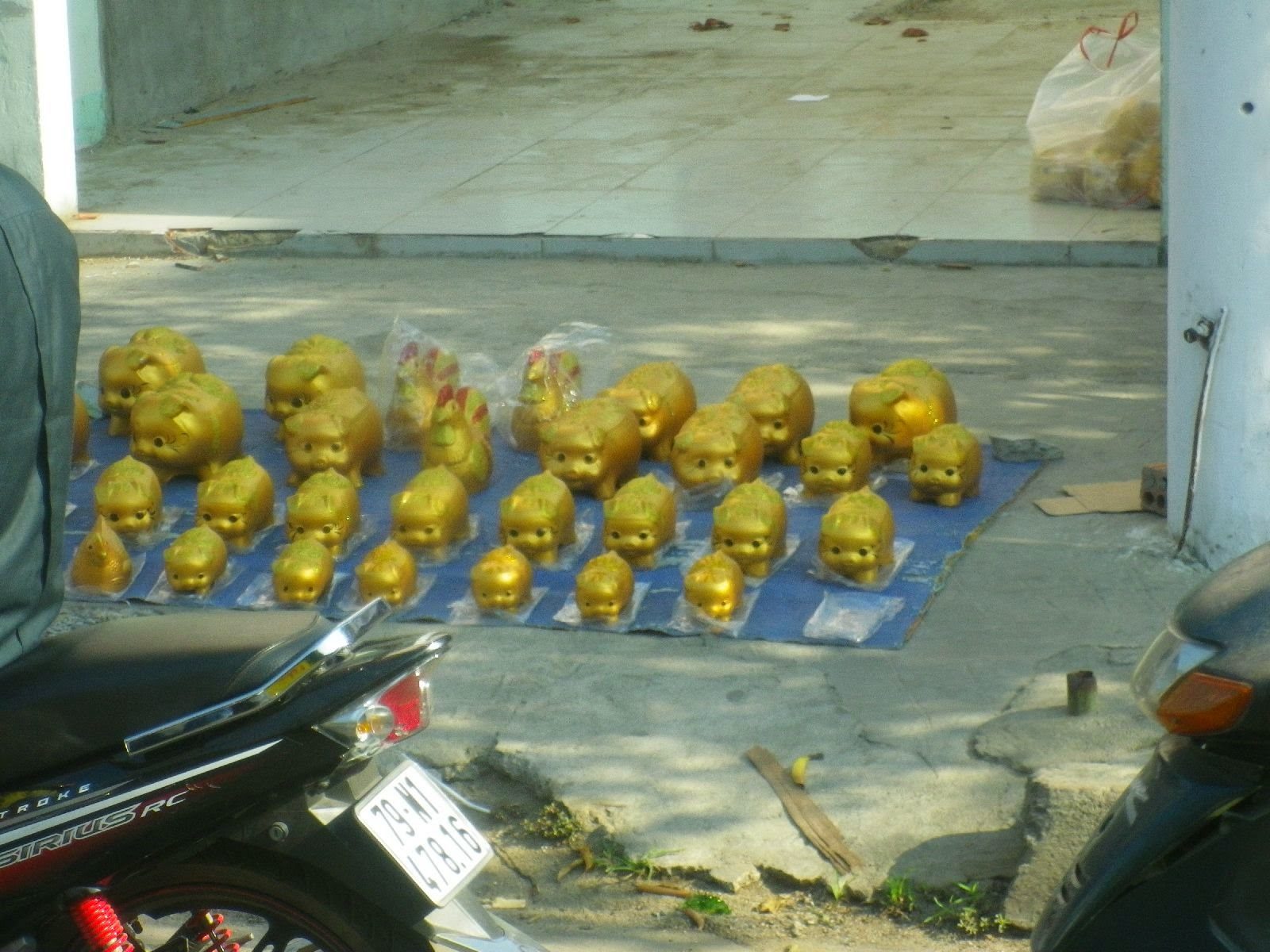 ベトナムの路上に並ぶ金色の豚の置物