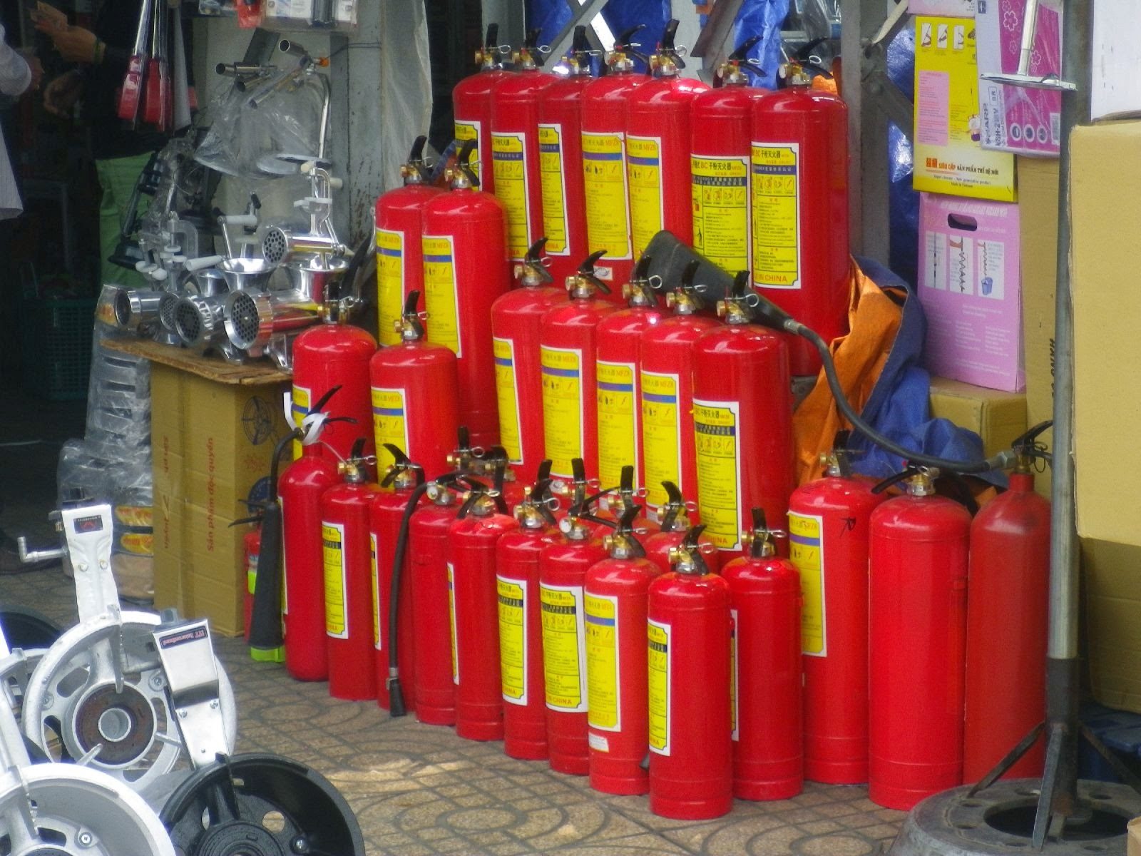 ホーチミン・チョロンの路上に積み上げられた赤い消火器
