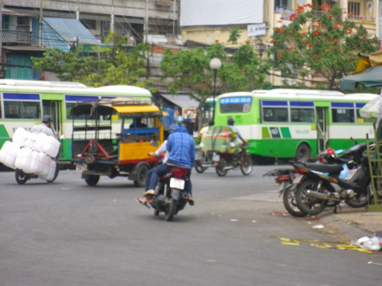 チョロンバスターミナル周辺を走るバイクと緑色のローカルバス