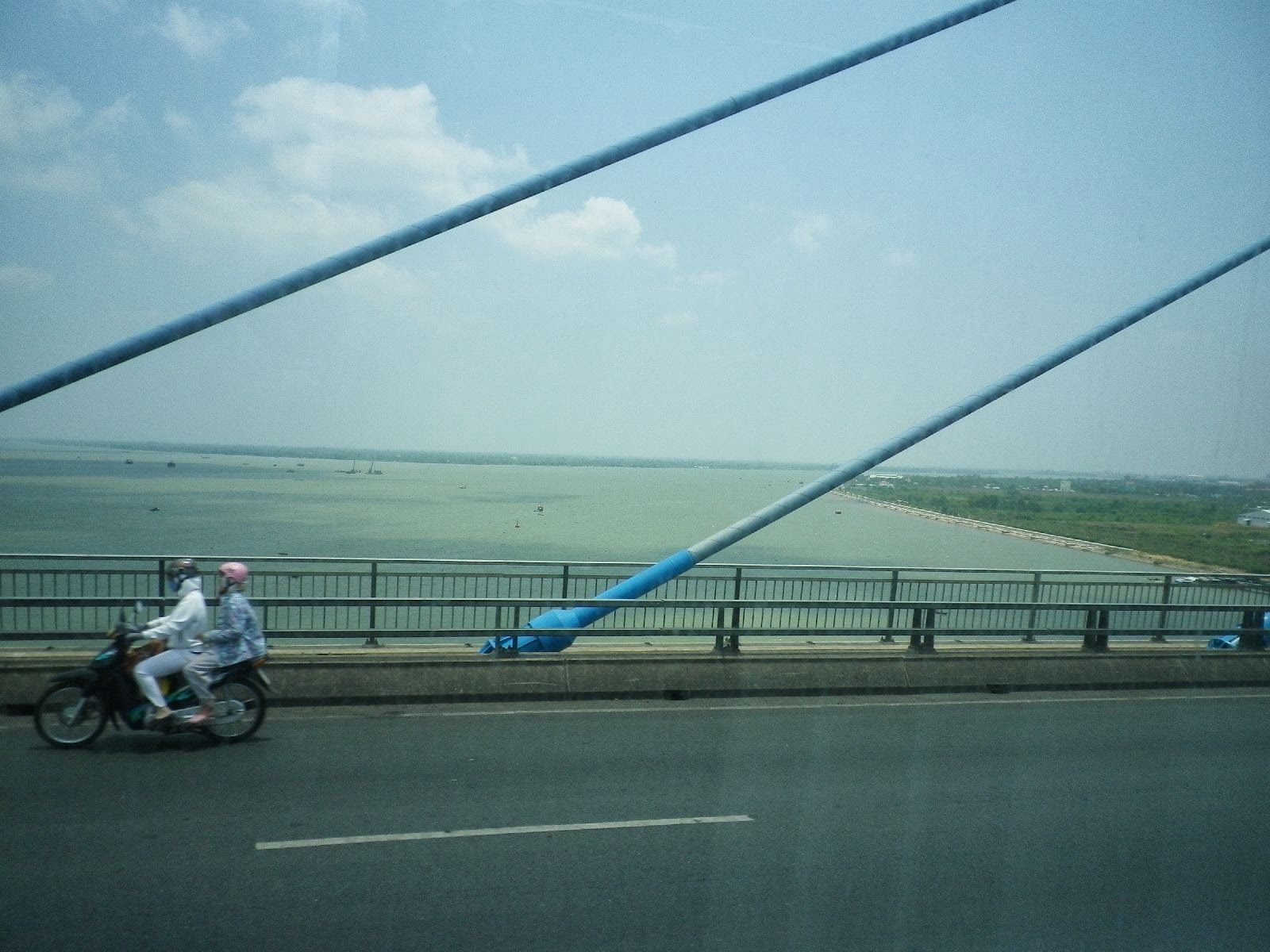 ベトナムの斜張橋を走るバイクとメコン川の眺め