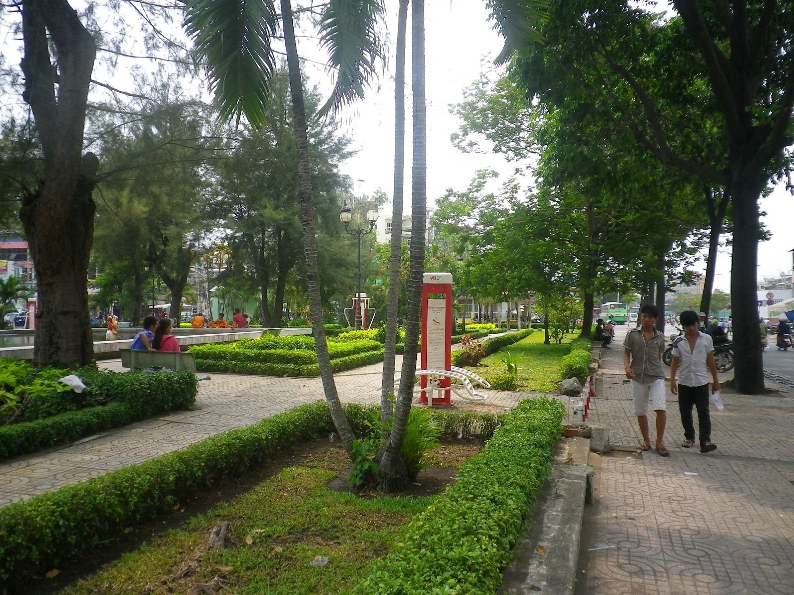 チョロンの緑豊かな公園沿いを歩く人々