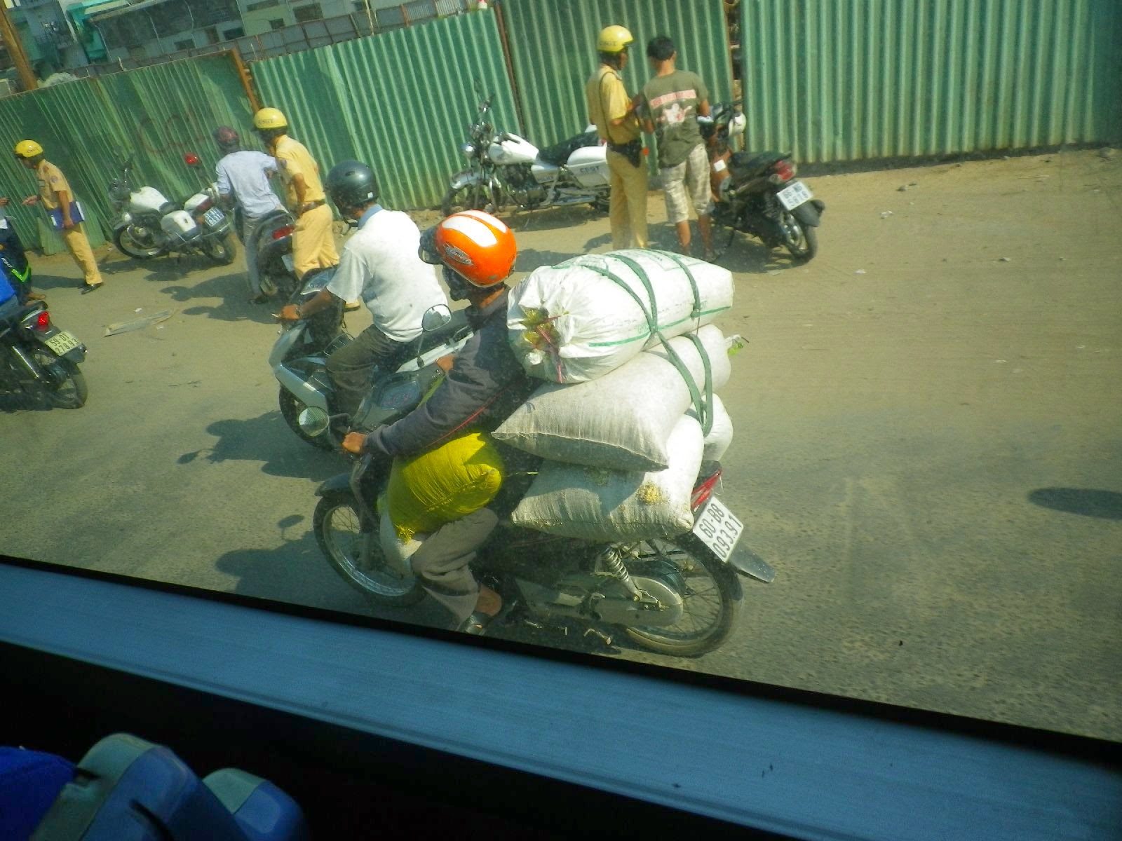 ベトナムの道路でバイクに大量の荷物を積んで走る様子