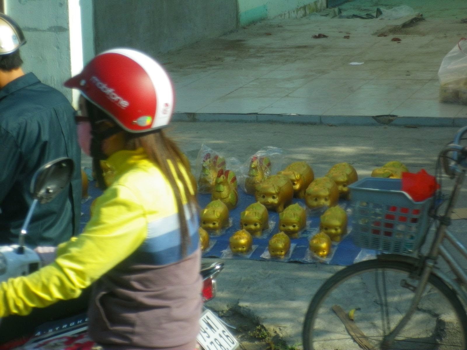 ベトナムの路上に並ぶ金色の人形みやげ物