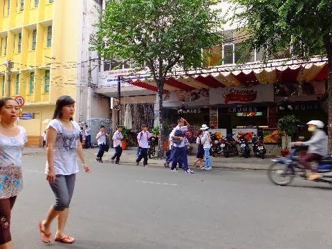 ホーチミンの路上を歩く学生たちと地元の人々