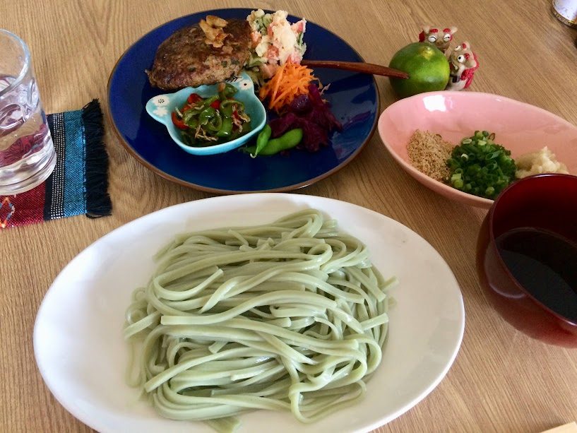 手延ゴーヤー麺の緑色の太麺とハンバーグのプレート