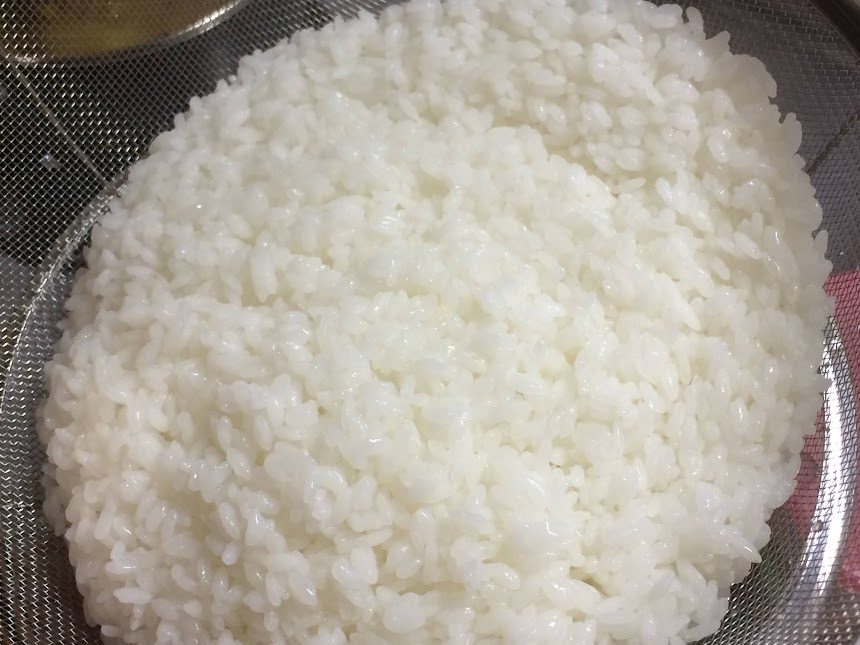 ざるに盛られたつやつやの白米アップ