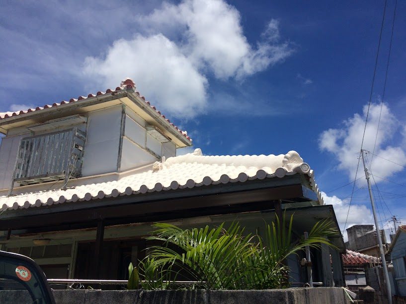 沖縄の民家屋根に鎮座する白いシーサー（家獅子）