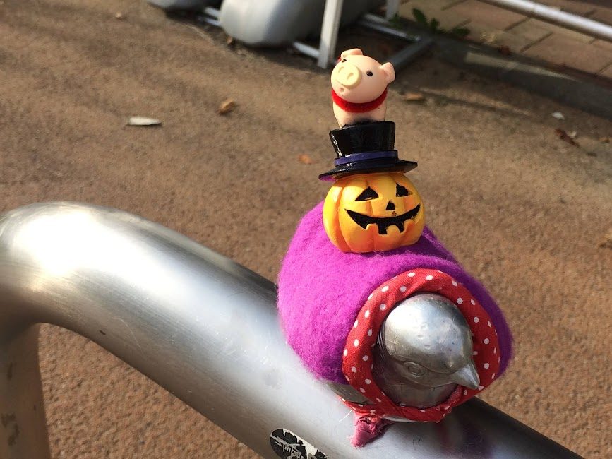 自転車のベルにハロウィンかぼちゃと豚の置物を飾った遊び心ある演出