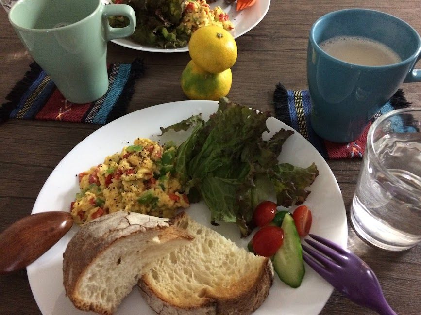 カラフルな野菜スクランブルエッグとパンの朝食プレート