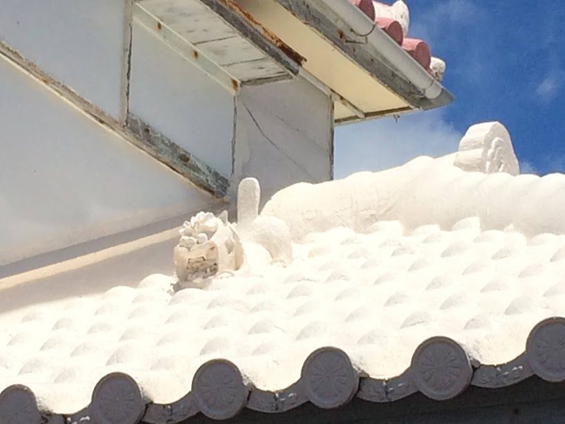 沖縄の建物屋根に鎮座する白いシーサー