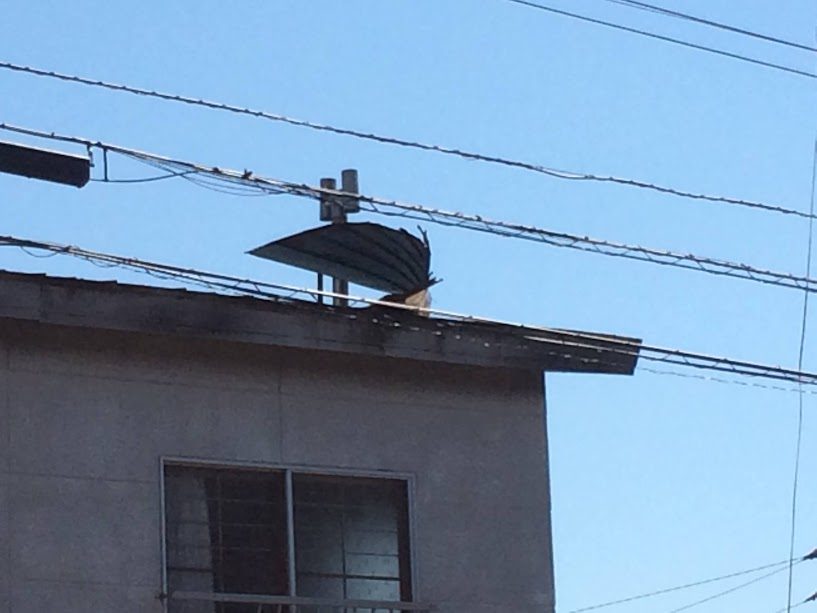 函館の強風で屋根がリーゼント状にめくれ上がった建物
