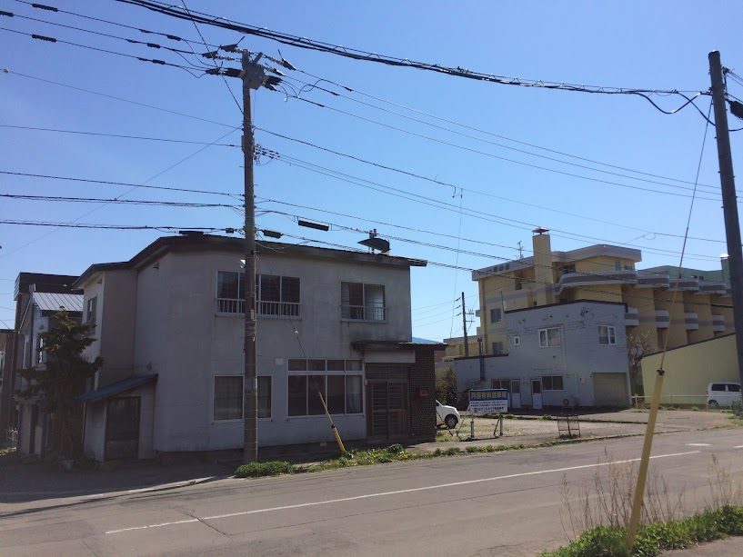 函館の古い二階建て建物と電線が交差する街角