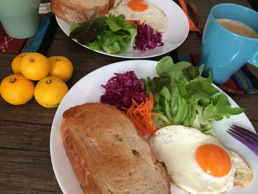 トーストと目玉焼き・サラダが並ぶ朝食プレートとコーヒー