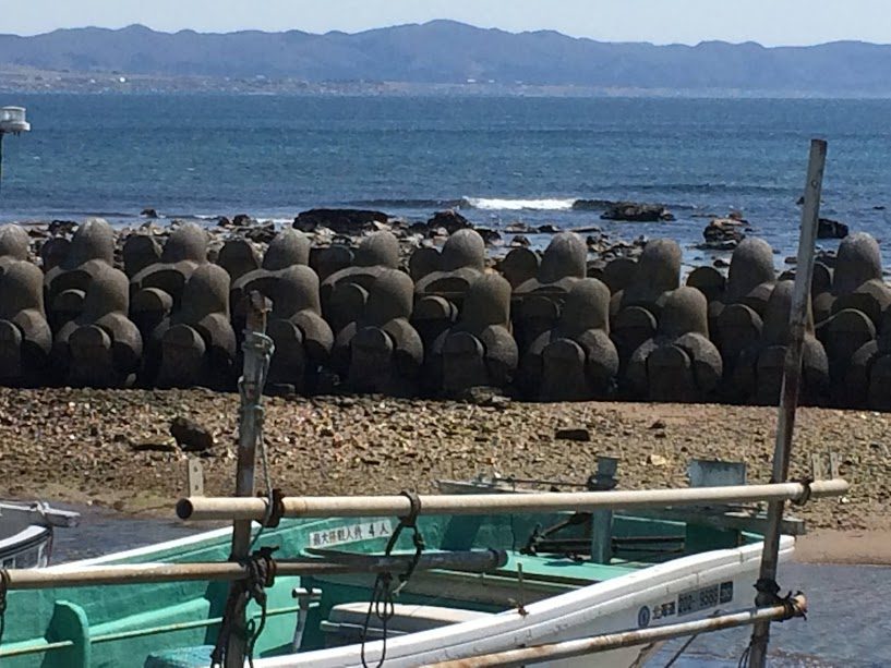 函館海岸に並ぶ丸型テトラポットと漁船