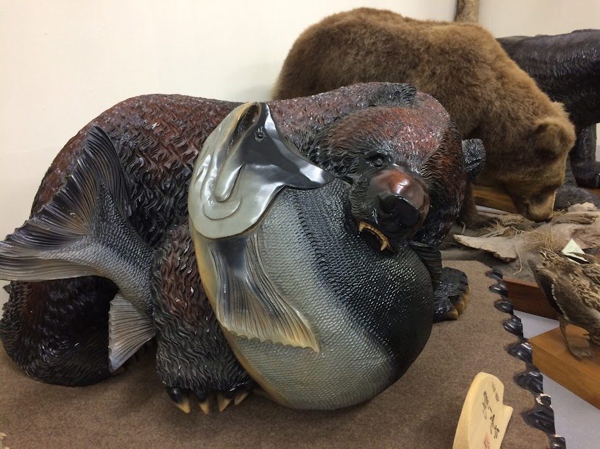 八雲町の木彫り熊資料館に展示された鮭をくわえる熊の木彫り