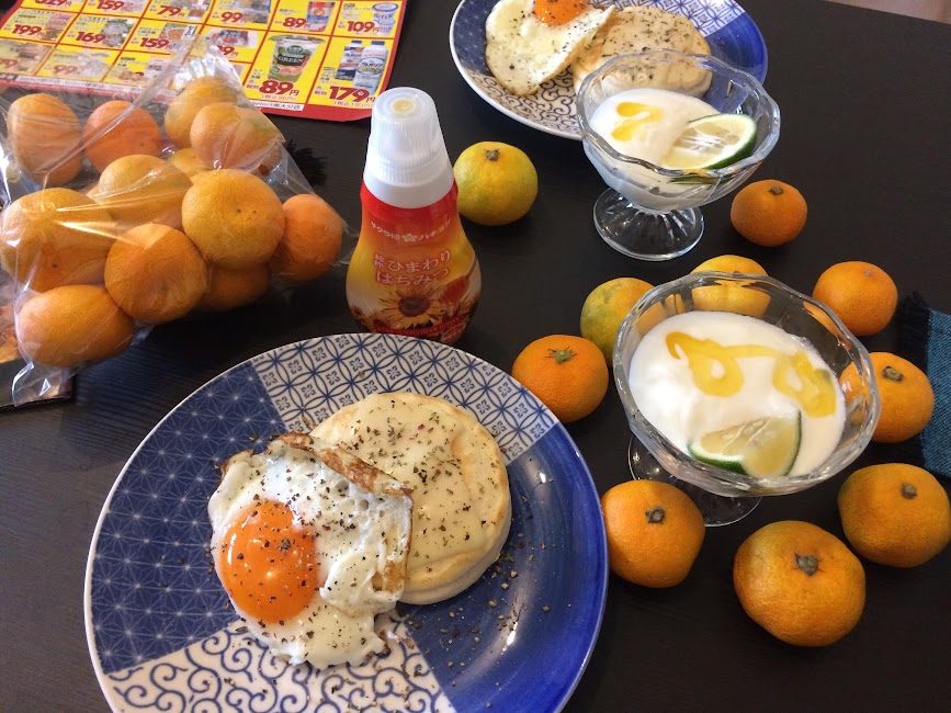 美彩卵の目玉焼きとヨーグルト、みかんを並べた自炊朝食