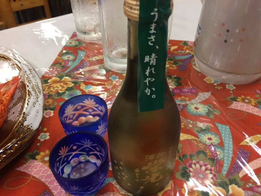 栄光酒造の日本酒と青色切子グラスが並ぶ宴席